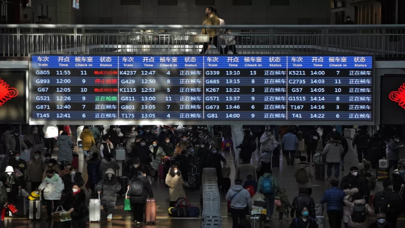 Viajantes entran a los andenes de una estación de trenes, el 15 de enero de 2023, en Beijing.